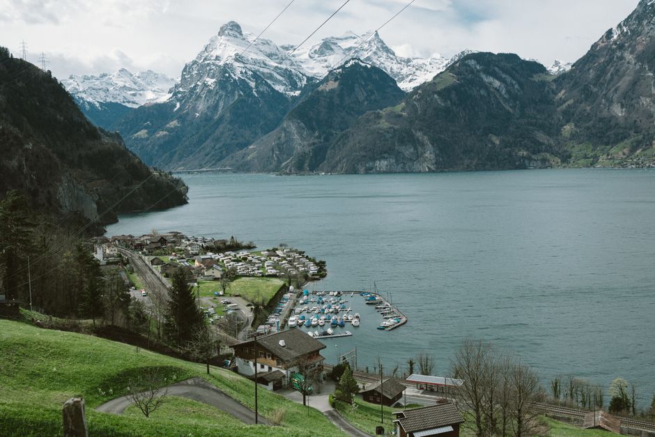 Scenic aerial view of a Swiss village surrounded by lake and mountains, perfect for travel and nature enthusiasts.